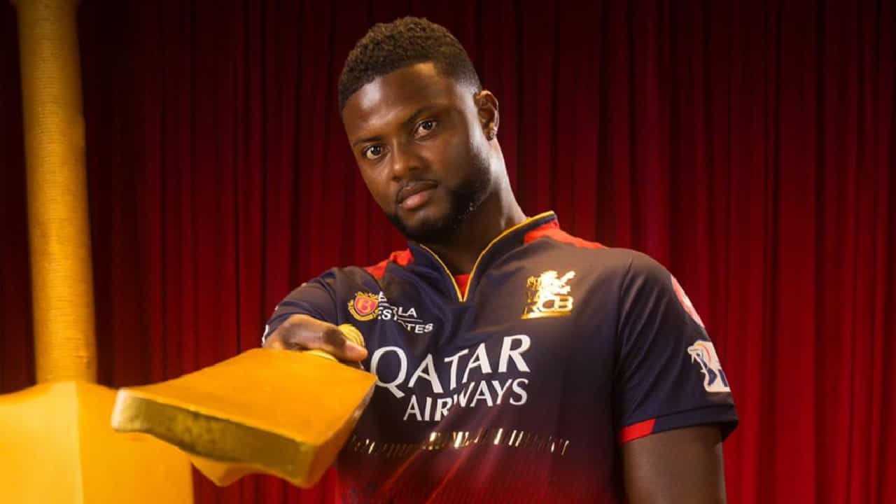 IPL 2025: ಇಂಡಿಯನ್ ಪ್ರೀಮಿಯರ್ ಲೀಗ್ ಸೀಸನ್-18ರಲ್ಲಿ ಭರ್ಜರಿ ಪ್ರದರ್ಶನ ನೀಡುತ್ತಿರುವ ರಾಯಲ್ ಚಾಲೆಂಜರ್ಸ್ ಬೆಂಗಳೂರು (RCB) ತಂಡಕ್ಕೆ ಆಘಾತದ ಮೇಲೆ ಆಘಾತ ಎದುರಾಗಿದೆ. ಒಂದೆಡೆ ಪ್ರಮುಖ ವೇಗಿ ಜೋಶ್ ಹ್ಯಾಝಲ್ವುಡ್ ಭುಜದ ನೋವಿನಿಂದ ಬಳಲುತ್ತಿದ್ದರೆ, ಮತ್ತೊಂದೆಡೆ ರೊಮಾರಿಯೊ ಶೆಫರ್ಡ್ (Romario Shepherd) ನಿರ್ಣಾಯಕ ಪಂದ್ಯಗಳಿಗೆ ಅಲಭ್ಯರಾಗಲಿದ್ದಾರೆ ಎಂಬ ಸುದ್ದಿ ಹೊರಬಿದ್ದಿದೆ.