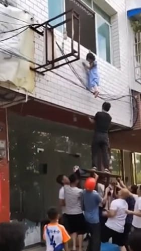 ಗೋಡೆಯಲ್ಲಿ ನೇತಾಡುತ್ತಿದ್ದ ಬಾಲಕಿಯನ್ನು ರಕ್ಷಿಸಲು ಜನರ ಹರಸಾಹಸ