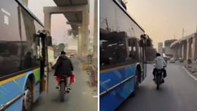 Video: ಬೈಕ್​​ನಲ್ಲಿ ಹೋಗುತ್ತಾ ಚಲಿಸುತ್ತಿದ್ದ ಬಸ್ಸಿನ ಬಾಗಿಲು ತೆರೆದ ಸವಾರ