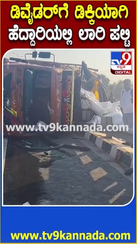 ಡಿವೈಡರ್​ಗೆ ಡಿಕ್ಕಿಯಾಗಿ ಹೆದ್ದಾರಿಯಲ್ಲಿ ಲಾರಿ ಪಲ್ಟಿ