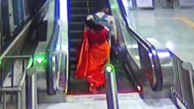 ಮಗುವಿನ ಸಮೇತ ಎಸ್ಕಲೇಟರ್​ನಿಂದ ಬೀಳೋಕಾದ ಮಹಿಳೆ