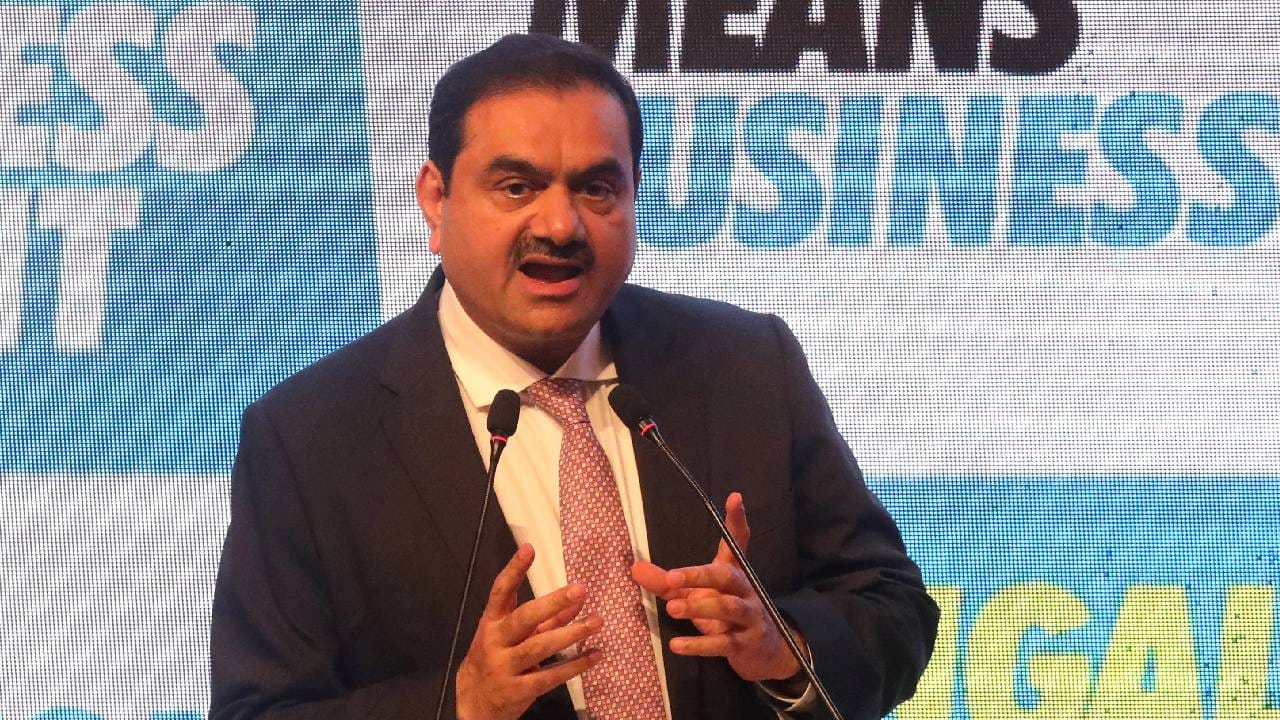 Gautam Adani in a business suit, looking confident at a press conference