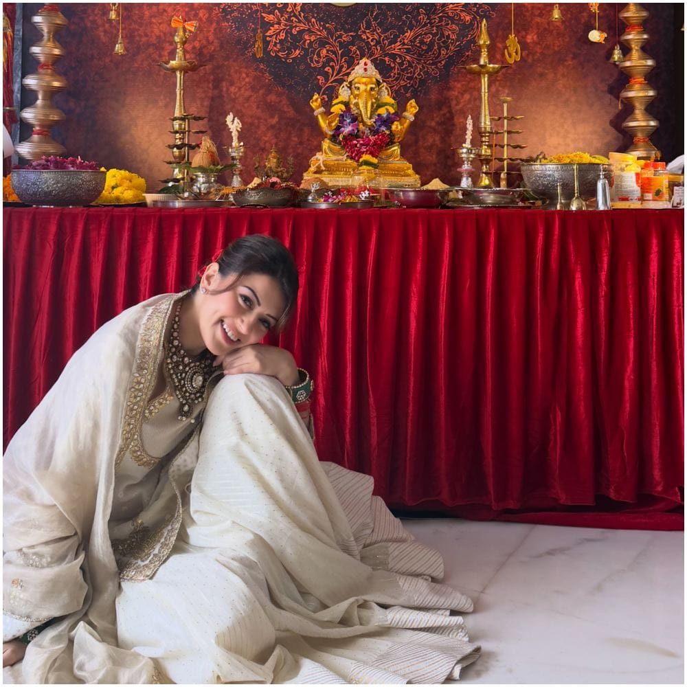 ಸಂಪ್ರದಾಯಿಕ ಬಿಳಿ ಉಡುಪಿನಲ್ಲಿ ದೀಪ ಹಾಗೂ ಅದ್ಧೂರಿ ಹಿನ್ನೆಲೆಯಲ್ಲಿ ಚಿನ್ನದ ಬಣ್ಣದ ಗಣಪತಿ ವಿಗ್ರಹದ ಮುಂದೆ ಕುಳಿತು ಹನ್ಸಿಕಾ ಸಂಭ್ರಮಿಸಿದ್ದಾರೆ.